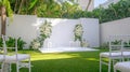 Elegant Outdoor Wedding Ceremony Setup with White Flowers and Chairs in a Tropical Garden Royalty Free Stock Photo
