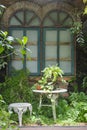 White chair and beautiful vintage window frames in the cottage garden Royalty Free Stock Photo