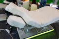 White chair for cosmetic procedures with electrically adjustable tilt and height