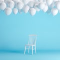 White chair with floating white balloons in blue background room studio.