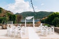 White chairs decorated with fabric stand in front of a wedding arch in a garden by the sea Royalty Free Stock Photo