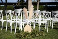 white chairs in the garden for a wedding ceremony. Outdoor event decoration Royalty Free Stock Photo