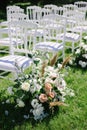 White chairs lined up for wedding ceremony. flower composition, decoration Royalty Free Stock Photo