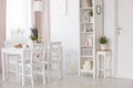 White chairs and table with flowers under lamp in dining room interior with lavender flowers. Real photo