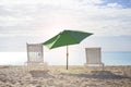 White chairs and umbrella at a beach at sunset time Royalty Free Stock Photo