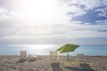 White chairs and umbrella at a beach at sunset time Royalty Free Stock Photo