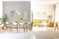 White chairs at wooden dining table in bright apartment interior Royalty Free Stock Photo