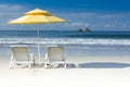 2 white chairs and yellow umbrella on tropical beach Royalty Free Stock Photo