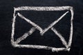 White chalk drawing in mail envelope icon on black board Royalty Free Stock Photo