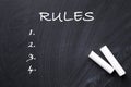 White chalk sticks on blackboard with list of rules