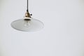 White chandelier plafond with a light bulb on a black cord on a white background