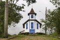 Colonial chapel framed by trees and foggy background, Catas Altas, Minas Gerais, Brazil