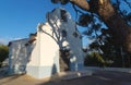 White chapel `Ermita de Sant Vicent` sunlit with shadows from big tree in La Nucia, Costa Blanca, Spain