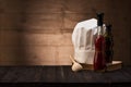 White chef`s hat and old cookbook on the kitchen table Royalty Free Stock Photo