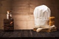 White chef`s hat and old cookbook on the kitchen table