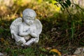 White cherub angel sitting in garden praying Royalty Free Stock Photo