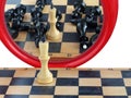 White chess king in front of mirror where he sees defeated opponents Royalty Free Stock Photo