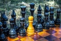 White chess pawn standing with black pieces on the chessboard. The concept of espionage, betrayal, agents