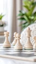 White chess pieces are meticulously positioned on a chessboard in a contemporary office environment, creating a focused Royalty Free Stock Photo
