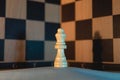 White chess queen in a symmetrical shot with the black and white checkered pattern background