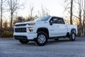 White Chevy Silverado 2500 surrounded by woods outdoors