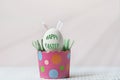 White chicken egg with bunny ears in an eco-friendly pink paper tray, box. Happy Easter holiday concept. English text Happy Easter Royalty Free Stock Photo