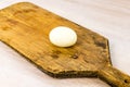 White chicken egg hard boiled peeled on old rustic wooden cutting board on white table background Royalty Free Stock Photo