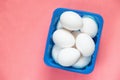 White chicken eggs in a blue box on a pink background close=up Royalty Free Stock Photo