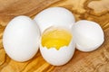 White chicken eggs and broken eggs on wooden board or table. close up Royalty Free Stock Photo