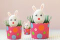 White chicken eggs with bunny ears in eco friendly pink paper trays, boxes. Family.Happy Easter holiday concept