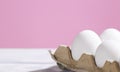 White Chicken eggs in a cardboard box on a pink background, Raw Fresh Eggs in a paper container, Natural Eko Product Royalty Free Stock Photo