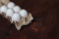White chicken eggs in a cardboard box from the store on a brown table before Easter Royalty Free Stock Photo