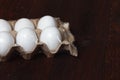 White chicken eggs in a cardboard box from the store on a brown table before Easter Royalty Free Stock Photo