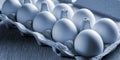 White chicken eggs in a cardboard cassette. Fabric background. Tinting. Close up. Royalty Free Stock Photo