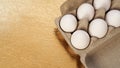 White chicken eggs in a cardboard tray on a gold background Royalty Free Stock Photo