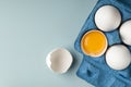 White chicken eggs in eco-packaging on a blue background. Broken egg with yolk in the shell. Farm natural products. Top view. Copy Royalty Free Stock Photo