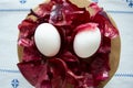 White chicken eggs in red onion husks on a white embroidered tablecloth. Royalty Free Stock Photo