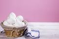 White Chicken eggs in a Straw basket on a pink background with piece of cloth, Natural Product Royalty Free Stock Photo