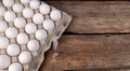 ÃÂ¡hicken eggs in tray and two small feathers near on table