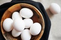White chicken eggs in a wooden bowl on a dark towel Royalty Free Stock Photo
