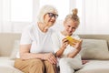 Family grandmother togetherness granddaughter child bonding smiling hugging sofa phone selfie Royalty Free Stock Photo