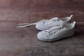 White children sneakers on a old textured wood background