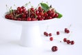 White china bowl filled with juicy fresh cherries on white background. Fresh mandarins fruit for healthy life and detox Royalty Free Stock Photo