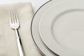 White china plates, fork and linen cloth napkin place setting Royalty Free Stock Photo