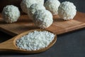 White chocolate ball candy with coconut topping and coconuts in wooden spoon Royalty Free Stock Photo