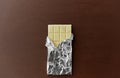 White chocolate bar in foil wrapper on brown Royalty Free Stock Photo