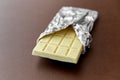 White chocolate bar in foil wrapper on brown Royalty Free Stock Photo