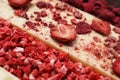 White chocolate bar with freeze dried strawberries as background, closeup Royalty Free Stock Photo