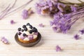 White chocolate and blueberry sable tartelette on a white drift wood table with purple dry flowers background Royalty Free Stock Photo