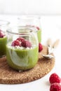 White chocolate cream mousse with matcha, avocado, pistachio, fresh raspberries - healthy vegan dairy free, gluten free